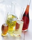 Підвищений вид на різноманітні види рослинної олії та оцту в скляних пляшках — стокове фото