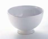 Вид крупным планом одной белой чаши на белой поверхности — стоковое фото