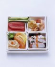 Four square bowls with sashimi — Stock Photo