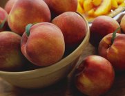 Свежие персики в миске — стоковое фото