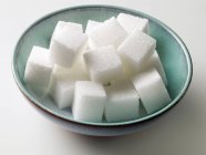 Vista de perto de cubos de açúcar branco na tigela — Fotografia de Stock