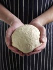 Closeup view of hands holding ball of dough — Stock Photo