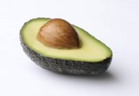 Half an avocado with seed — Stock Photo