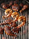 Vue rapprochée de crevettes grillées et brochées sur le gril avec cuisses de poulet — Photo de stock