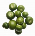 Viele rohe grüne Tomatillos auf weißem Hintergrund — Stockfoto