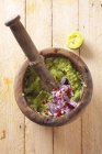 Guacamole with onions in a mortar  over wooden surface — Stock Photo