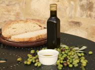 Pan con aceite de oliva prensado en frío y aceitunas - foto de stock