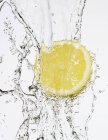 Half a lemon under flowing water — Stock Photo