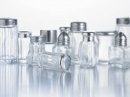 Closeup view of various salt shakers on white surface — Stock Photo