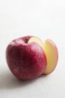 Manzana roja con una rebanada quitada - foto de stock