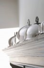 Closeup view of silver cloches on top of a cupboard — Stock Photo