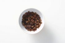 Bowl of brown raisins — Stock Photo