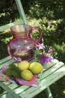 Lemons and jug of water — Stock Photo