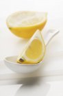Лимонний клин на ложці з половиною лимона — стокове фото