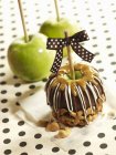 Vista close-up de caramelo e maçã coberta de chocolate com caju e maçãs — Fotografia de Stock