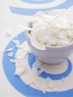Coconut flakes in ceramic bowl — Stock Photo