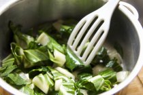 Chard being fried in pan with server — Stock Photo
