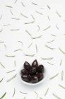 Каламата оливки в миску і листя — стокове фото