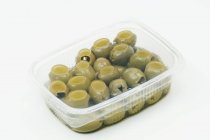 Grüne Oliven im Plastikbehälter — Stockfoto