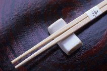 Vista close-up de pauzinhos de madeira com um resto chopstick — Fotografia de Stock