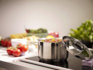 Помідори готують на плиті в інтер'єрі кухні — стокове фото
