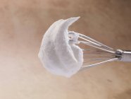 Closeup view of whipped cream on a whisk — Stock Photo