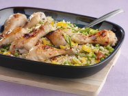 Chicken legs on bed of vegetable rice — Stock Photo