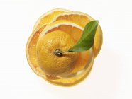 Mitades naranjas con hoja - foto de stock