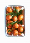 Mandarins with leaves in basket — Stock Photo