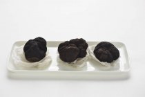 Three Perigord truffles on paper — Stock Photo