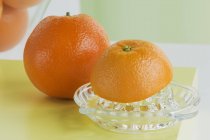 Naranjas con exprimidor de cítricos - foto de stock
