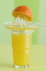 Copo de suco de laranja com espremedor — Fotografia de Stock