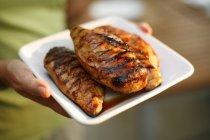 Woman Holding Grilled Chicken Breasts — Stock Photo