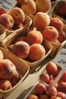 Органические персики в корзинах — стоковое фото