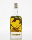 Una botella de aceite de hierbas con ajo y chile - foto de stock