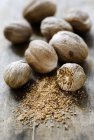 Whole and grated Nutmegs — Stock Photo