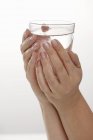 Mains tenant un verre d'eau — Photo de stock