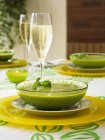 Cream of pea soup with glass of champagne — Stock Photo