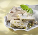 Closeup view of Halva with pistachios and mint leaves in bowl — Stock Photo