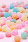 Vista de cerca de las bolas de goma de mascar en azúcar en la superficie de color rosa - foto de stock