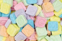 Primo piano vista di caramelle dai colori vivaci con lettere timbrate — Foto stock