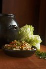 Кимчи в миске со свежей китайской капустой на деревянной поверхности — стоковое фото