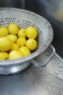Щойно промивають лимони в друшляк — стокове фото