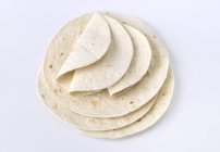 Elevated view of stacked Tortillas on white surface — Stock Photo