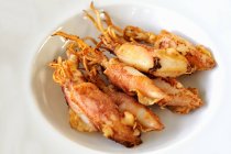 Closeup view of fried cuttlefish in white bowls — Stock Photo