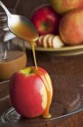 Salsa di caramello versando sopra mela — Foto stock