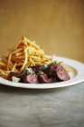 Sliced steak with french fries — Stock Photo