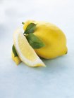Лимон зі скибочками і листям — стокове фото
