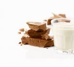 Milch und Schokoladenstücke — Stockfoto