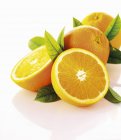 Свежие спелые апельсины с листьями — стоковое фото
